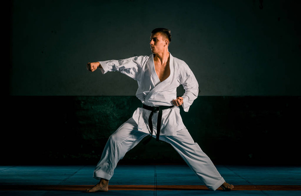 Egy Judoka harcos kimonóban gyakorol a tornateremben. - Fotó, kép