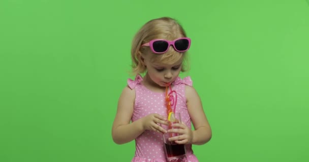 Kind in rosa Badeanzug trinkt Saftcocktail mit Trinkhalm. Chroma-Schlüssel - Filmmaterial, Video