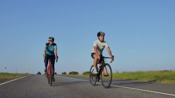 Σκληρή εκπαίδευση. triathlete δύο ποδηλατικές προπονήσεις στο οδικό ποδήλατο. δύο ποδηλάτης ιππασία στο οδικό ποδήλατο στο πάρκο της πόλης και να ετοιμαστείτε για τρίαθλο. Fit αθλητής εντατική εκπαίδευση δύο άντρας και γυναίκα Ποδηλασία - Πλάνα, βίντεο