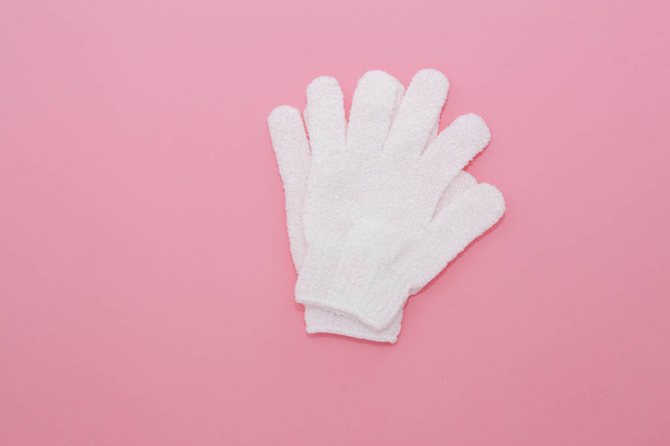Woman exfoliating massage glove for shower on pink background. - Photo, Image