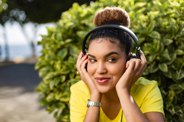 Όμορφη νεαρή μαύρη αφρικανική Αμερικανίδα γυναίκα ακούγοντας μουσική εξυπνάδα - Φωτογραφία, εικόνα