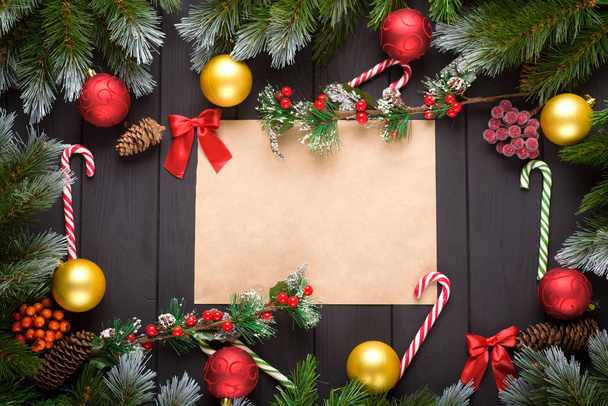 Vánoce nebo nový rok dekorace: jedle-stromové větve, barevné koule, cukrová třtina na černém pozadí. Pohled shora s prostorem kopírování. Falt ležel - Fotografie, Obrázek