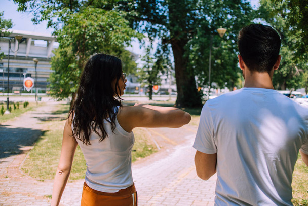 Портрет веселої усміхненої пари, молодий чоловік і брюнетка розмовляють на прогулянці в парку
 - Фото, зображення