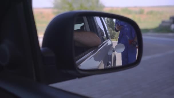 Blick durch den Seitenspiegel, wie man ein Auto füllt. Benzin tanken im Auto an der Tankstelle. Tanken mit Zapfpistole an der Zapfsäule - Filmmaterial, Video