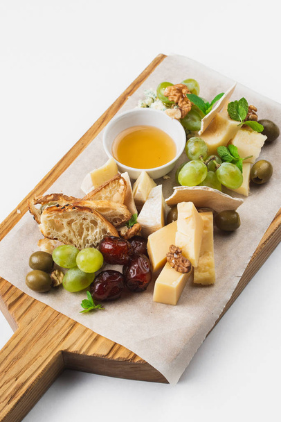 ahşap tahta üzerinde çeşitli peynir ve bal - Fotoğraf, Görsel