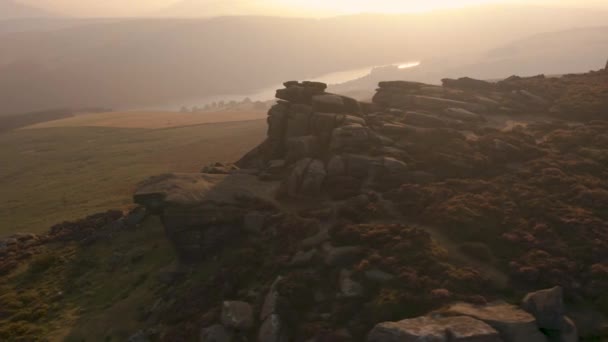 Gün batımında Peak District Milli Parkı'ndaki kayaların etrafında havadan döner - Video, Çekim
