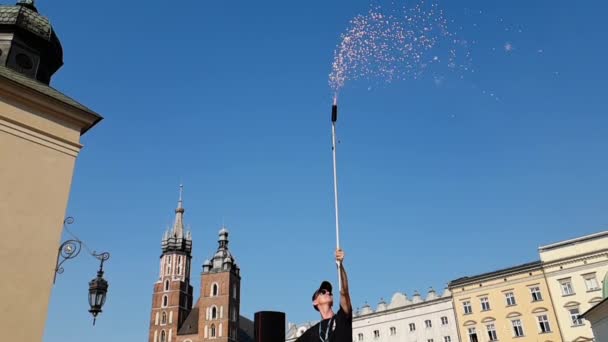 Hombre alegre de pie y manteniendo un tubo largo con fuegos artificiales en Cracovia en verano
 - Imágenes, Vídeo