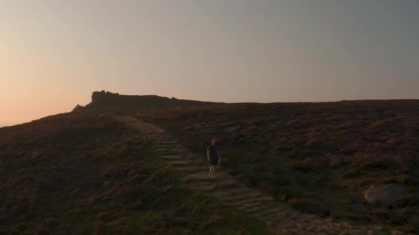Antenne - einem jungen Mann beim Klettern entlang eines atemberaubenden Hangs bei Sonnenuntergang folgen - Filmmaterial, Video