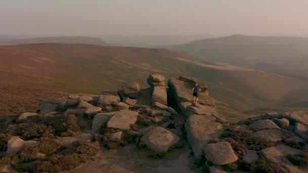 Aérienne - Suivre un jeune mâle grimpant le long d'une magnifique colline au coucher du soleil
 - Séquence, vidéo