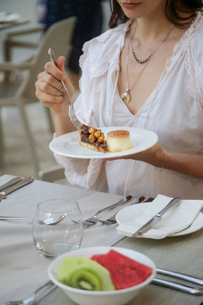 Woman having dessert, Creme caramel custard and a piece of chocolate tart - Foto, imagen