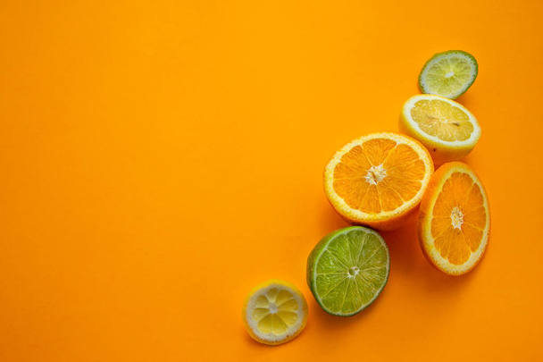 Owoce cytrusowe: pomarańczowy, Limonkowy, cytrynowy na pomarańczowym tle - Zdjęcie, obraz