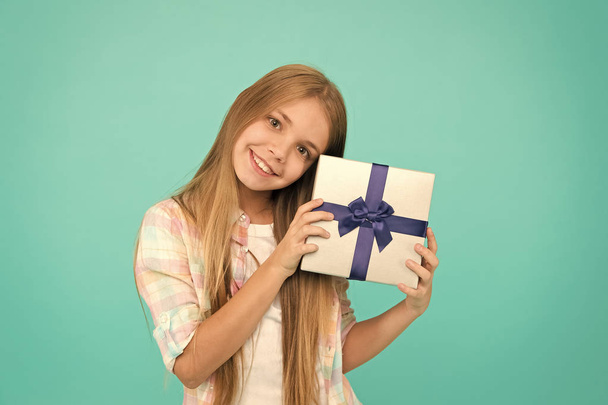 Making someone happy. Small child holding gift box tied with ribbon bow. Cute shopper enjoy doing a little shopping. Small girl after shopping for gift. Little shopaholic with present wrapped in box - Фото, зображення