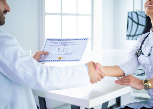 Dottore stringe la mano con un paziente isolato su sfondo bianco - Foto, immagini