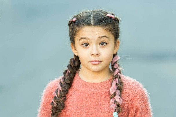 Girl with braided hair style with pink kanekalon. Hairdresser salon. Fancy look. Braided cutie. Little girl with cute braids close up. Kanekalon strand in braids of child. Braided hairstyle concept - Photo, Image