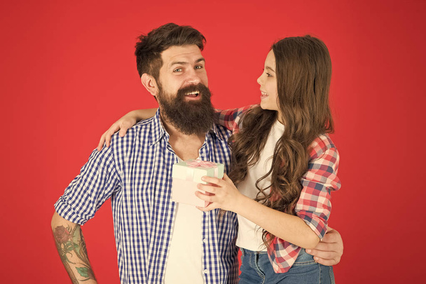 Happy fathers day. Man bearded father and cute little girl daughter on red background. Celebrate fathers day. Family values concept. Friendly relations. Father hipster and his daughter. Gift surprise - Foto, immagini