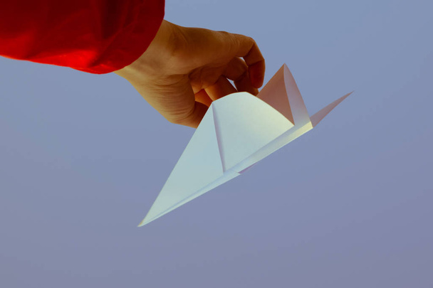 青空の手で白い紙飛行機。インターネット上の自由の象徴 - 写真・画像