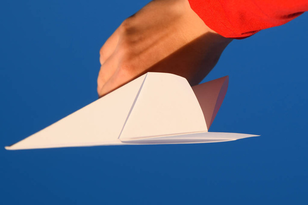 White paper airplane in hand against the sky. A symbol of freedom on the Internet - Fotoğraf, Görsel