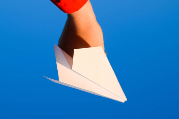 White paper airplane in hand against the sky. A symbol of freedom on the Internet - Φωτογραφία, εικόνα