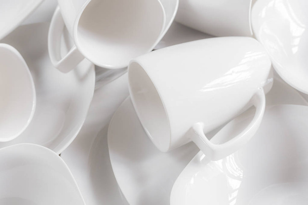 White ceramic cups and plates on wooden background, image - 写真・画像