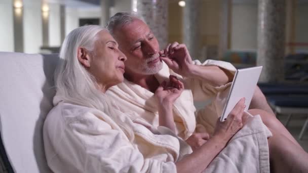 Old couple conversating online on tablet in hotel - Materiaali, video