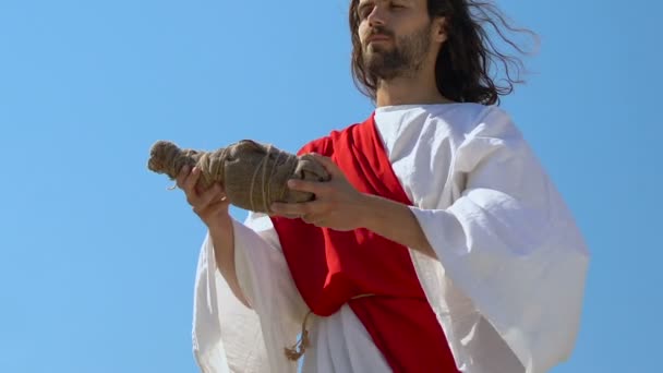 Jesus Christ in robe raising bottle to heaven, asking God for blessing water - Footage, Video