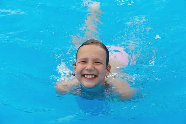 プールで泳いでいるの幸せな女の子 - 写真・画像