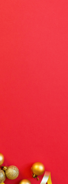 Composition de Noël. Cadeau enveloppé, jouets dorés sur fond rouge. nouvelle année concept. Bannière verticale pour la conception web. Carte de voeux, célébration de Noël 2020. Plat, vue du dessus, espace de copie, maquette
 - Photo, image