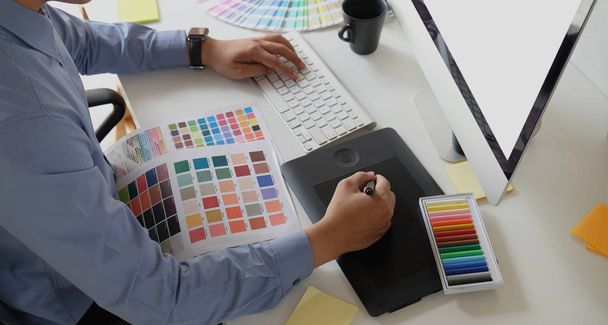 Návrhář grafiky pracující se vzorníky pro kreslení tabletu a barev - Fotografie, Obrázek