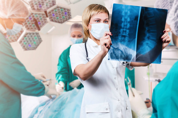 Γυναίκα γιατρός που κοιτάζει μια ακτινογραφία σπονδυλικής στήλης. - Φωτογραφία, εικόνα