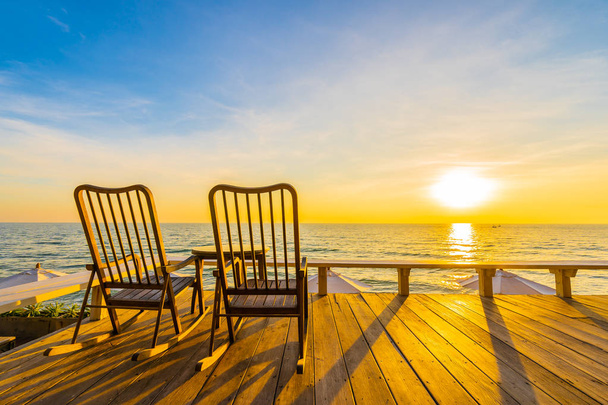 Cadeira de madeira vazia e mesa no pátio ao ar livre com belo tropi
 - Foto, Imagem