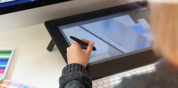Jonge ontwerper schetsen puttend uit grafisch tablet - Foto, afbeelding