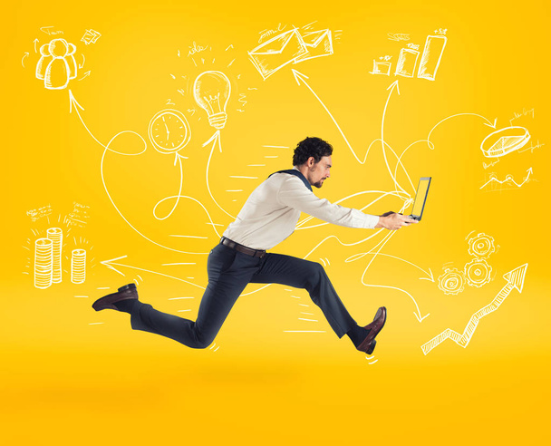 Fast business concept with businessman running with a laptop. Yellow background - Photo, Image