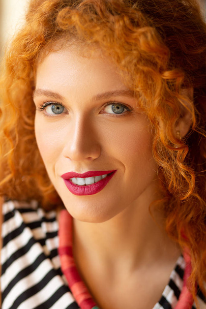 Beautiful blue-eyed woman with brassy curly hair - Foto, Imagen