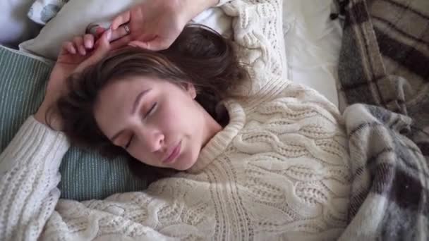 Top view of a sleeping girl in a white sweater, coziness and comfort - Imágenes, Vídeo