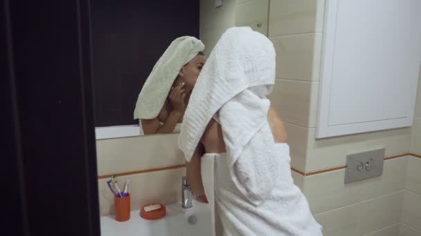Όμορφη γυναίκα βουρτσίζει τα δόντια της και κοιτάζει στον καθρέφτη. - Πλάνα, βίντεο