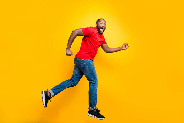 Full length body size photo of casual running man who aspires to achieve what he has planned while isolated with yellow background - Fotografie, Obrázek