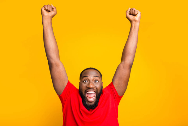 Photo of rejoicing enjoying happy american man screaming with pleasure while isolated with yellow background - Foto, Imagen