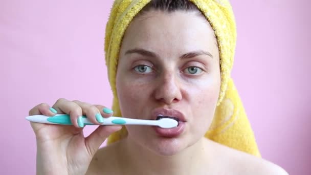 Młoda dziewczyna w ręczniku po prysznicem szczotek zębów. Rano samoopieki - Materiał filmowy, wideo