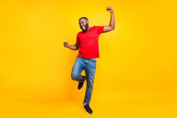 Full length body size photo of rejoicing glad cheerful happy black man dancing with joy while isolated with yellow background - Foto, afbeelding