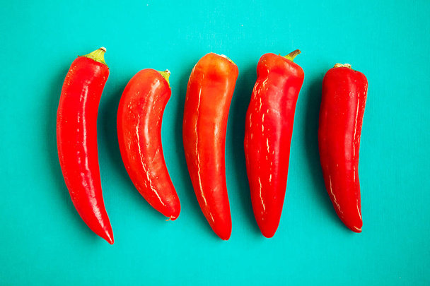 Red chili peppers on turquois background - Foto, Imagem
