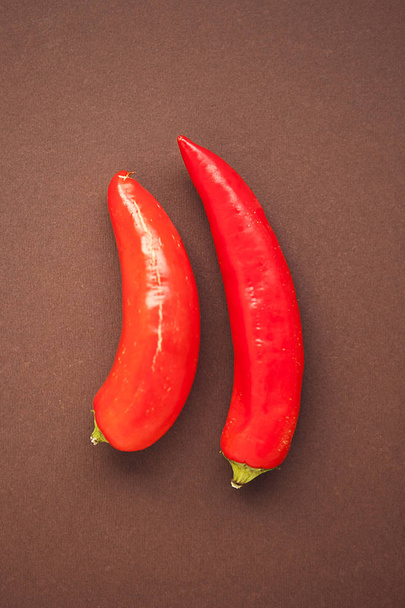 červené chilli papričky na hnědém pozadí - Fotografie, Obrázek