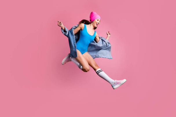 Full length photo of cheerful lady jumping screaming looking wearing denim jeans blue swimsuit isolated over pink background - 写真・画像