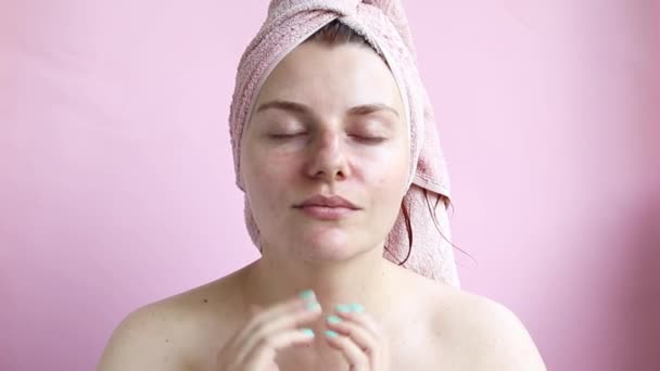 Duş kreminden sonra havlualan genç bir kız yüzünü lekeler. Yüz masajı. Sabah öz bakım - Video, Çekim