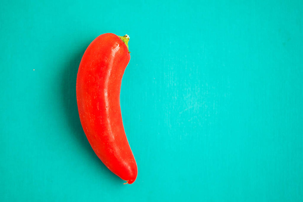 Red chili pepper on turquois background - Fotoğraf, Görsel