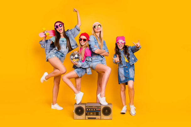 Full length size photo of group of four people carefree students having fun discotheque white parents are absent. Wearing denim outfit showing horned signs isolated yellow background - Foto, Bild