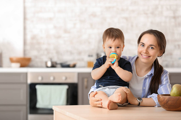 Matka a její malý syn s polovinkou v kuchyni doma - Fotografie, Obrázek