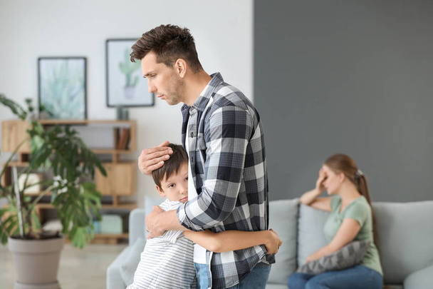 Hombre calmando a su hijo después de disputa familiar en casa
 - Foto, Imagen