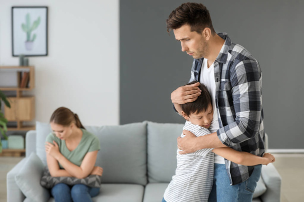 Man calming his son after family quarrel at home - Valokuva, kuva