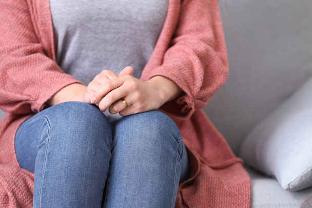 Triste mujer sentada en el sofá en casa, de cerca. Concepto de divorcio
 - Foto, imagen
