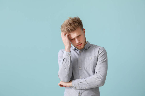 Стресс молодой человек на цветном фоне - Фото, изображение